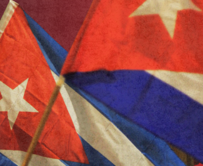 A imagem mostra duas bandeiras de Cuba tremulando em destaque, com seus icônicos tons de vermelho, branco e azul.