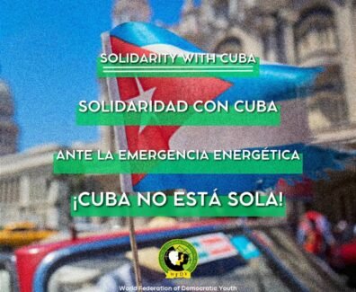 A imagem destaca uma bandeira cubana e uma mensagem de solidariedade à luta de Cuba contra a crise energética. A FMJD reafirma o apoio internacional à ilha, denunciando o bloqueio imposto pelos EUA.