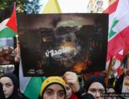 A imagem retrata manifestantes no Líbano segurando bandeiras da Palestina e do Líbano, além de cartazes que denunciam os bombardeios em Gaza e expressam solidariedade ao povo palestino. No centro, um cartaz com uma imagem de destruição exibe a palavra em árabe "resistência" sobre uma área devastada por bombardeios. O contexto remete à contínua ofensiva israelense e ao apoio internacional à causa palestina. A manifestação ilustra a indignação e o apoio dos libaneses à resistência palestina em meio ao conflito. Foto: Mohamed Azakir/Reuters.