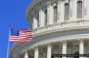 Bandeira dos Estados Unidos tremulando em frente à cúpula do Capitólio, em Washington, D.C.