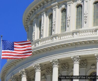Bandeira dos Estados Unidos tremulando em frente à cúpula do Capitólio, em Washington, D.C.