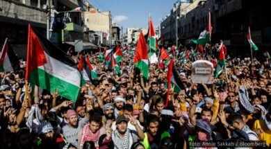 Protesto com uma multidão levantando bandeiras da Palestina em apoio à causa palestina.