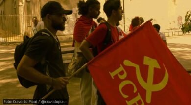 Grupo de jovens militantes da UJC no Piauí em ato público, com uma bandeira vermelha do PCB em destaque, em ambiente ao ar livre.