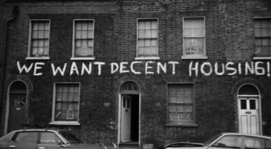 Fachada da Ocupaçao Connolly Barrack, na Irlanda, com uma faixa escrito "WE WANT DECENT HOUSING!"