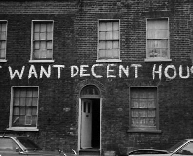 Fachada da Ocupaçao Connolly Barrack, na Irlanda, com uma faixa escrito "WE WANT DECENT HOUSING!"