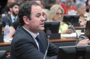 Deputado Glauber Braga falando ao microfone durante sessão na Câmara dos Deputados, com expressão séria, defendendo suas posições políticas em meio a processo de tentativa de cassação.