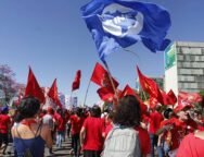 Militantes da União da Juventude Comunista em marcha contra os ataques a educação e aos direitos promovidos pelo governo Bolsonaro, com bandeiras da UNE da UJC.