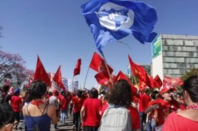 Militantes da União da Juventude Comunista em marcha contra os ataques a educação e aos direitos promovidos pelo governo Bolsonaro, com bandeiras da UNE da UJC.