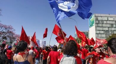 Militantes da União da Juventude Comunista em marcha contra os ataques a educação e aos direitos promovidos pelo governo Bolsonaro, com bandeiras da UNE da UJC.