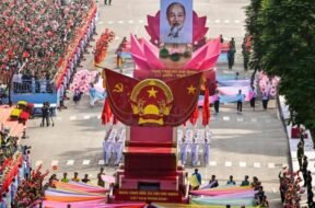 Um carro alegórico em forma de lótus carregava o retrato do líder revolucionário do Vietnã, Ho Chi Minh, perto da frente do desfile que marcava os 50 anos do fim da guerra. Fotografia: Nhac Nguyen / AFP / Getty Images.