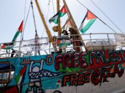 Imagem mostra ativistas a bordo de um barco com bandeiras da Palestina, murais com a frase “Free Gaza” e faixas de apoio às crianças de Gaza. A embarcação fazia parte da flotilha humanitária rumo à Faixa de Gaza.