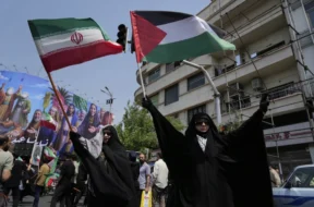 Manifestantes iranianos levantam bandeiras do Irã e da Palestina em um ato contra Israel em Teerã, Irã, na sexta-feira, 13 de junho de 2025. (AP Photo/Vahid Salemi)