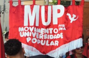 "Estandarte vermelho do Movimento por uma Universidade Popular (MUP) erguido em manifestação durante o 60º CONUNE. Foto: @0liveirdavi / UJC.